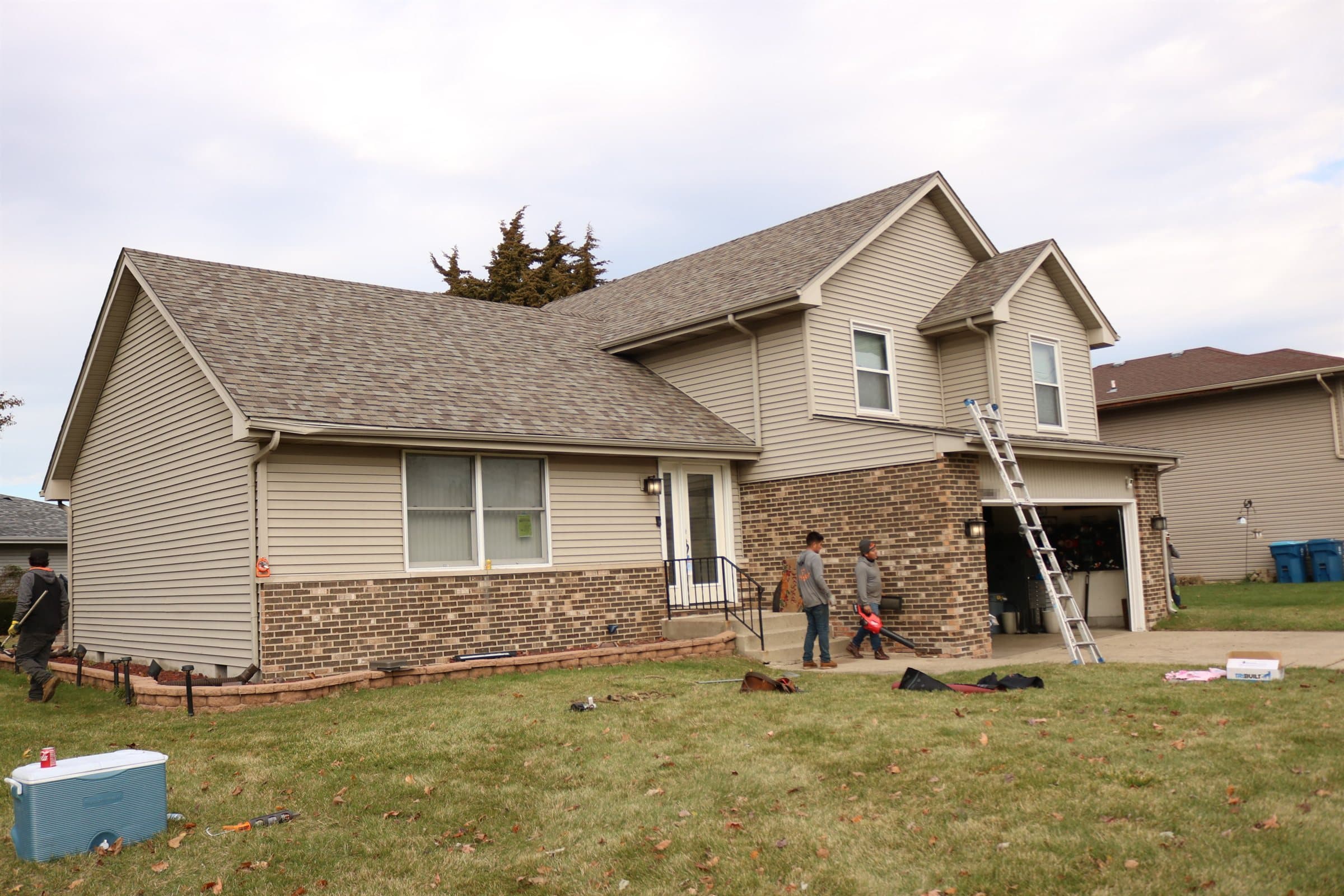 A two-storey single-family home with its completed replacement roof, photographed from the front lawn