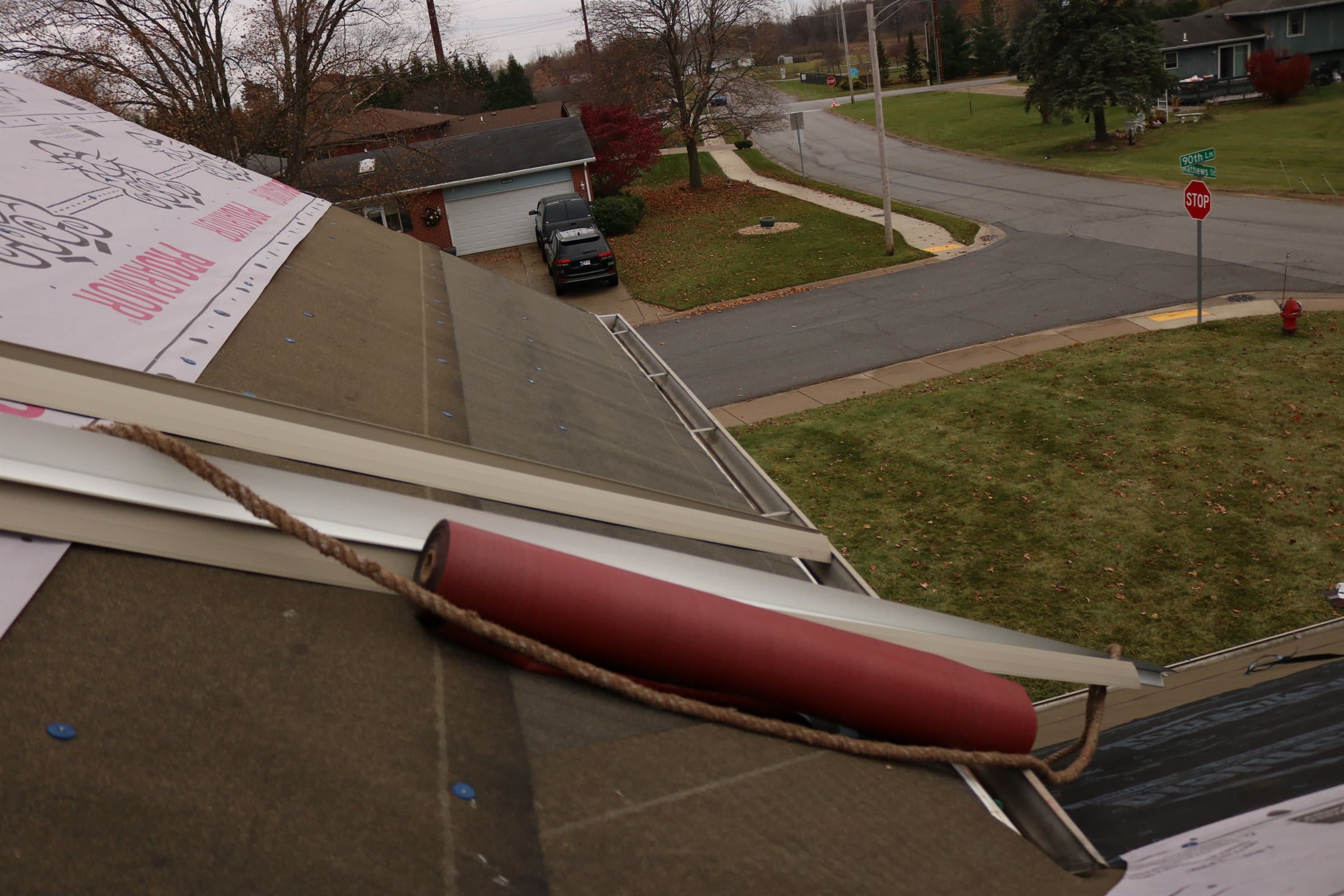 A gutter run along the eave of a roof mid-replacement, with drip edge and underlayment visible