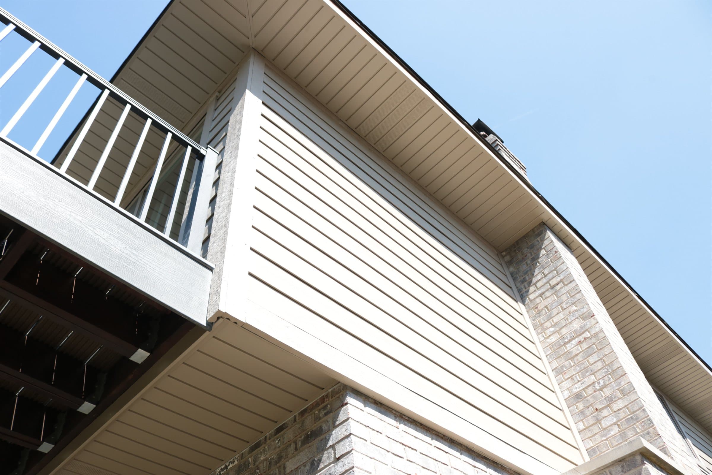 A finished gable end showing lap siding, soffit and fascia against a blue sky
