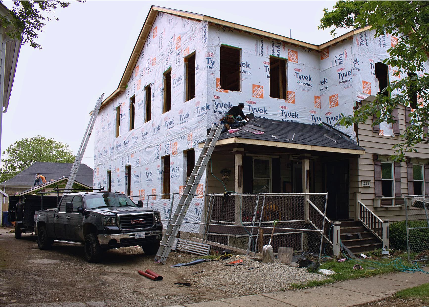 The same Chicagoland home mid-build, stripped back to housewrap before new siding